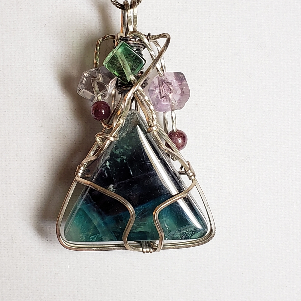 Artisan wire-wrapped triangular gem with a halo of smaller beads surrounding